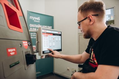 На фото — клиент пользуется терминалом самообслуживания в отделении ПУМБ. Удобный интерфейс и продуманная эргономика позволяют быстро производить необходимые операции.