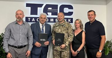 Фото представників Таскомбанку та військового ЗСУ з теками про підписання співпраці на фоні логотипа банку