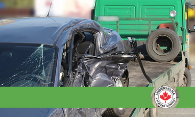 Пошкоджений легковий автомобіль з розбитим склом і зім’ятою бічною частиною завантажений на платформу евакуатора