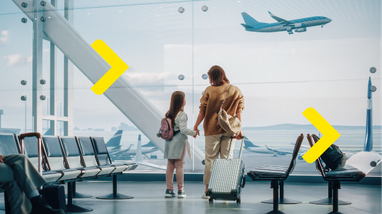 На зображенні мама та дитина стоять біля великого панорамного вікна в терміналі аеропорту, тримаючись за руки.
