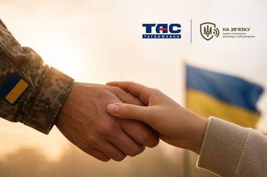 Рукопожатие военного в форме с флагом на рукаве и гражданского лица на фоне государственного флага