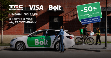 Рекламний банер спільної акції Таскомбанку, Visa та Bolt на тлі міської будівлі з червоної цегли. На передньому плані зображено білий автомобіль із великим зеленим логотипом «Bolt», біля відчинених дверей якого стоїть дівчина в джинсовому костюмі. Праворуч на тротуарі кур’єр із фірмовим зеленим рюкзаком «Bolt food» на велосипеді передає паперовий пакет дівчині.