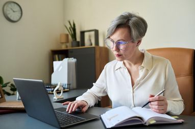 Работница проверяет страховой стаж за компьютером
