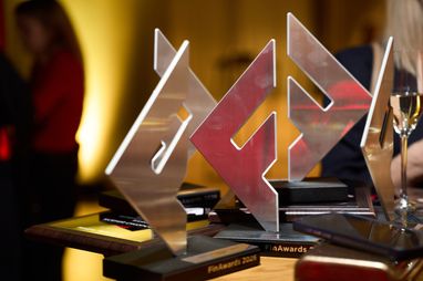 На зображенні представлено кілька нагород премії FinAwards 2026, які стоять на столі під час урочистого заходу.