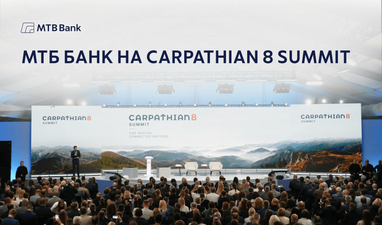 Зала з великою аудиторією та сценою, оформленою банером з написами «Carpathian 8 Summit» та видами гір; зверху розміщено напис «МТБ Банк на Carpathian 8 Summit» та логотип МТБ Банку.