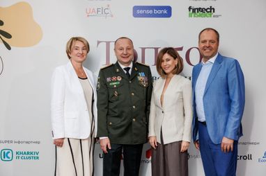 Групповое фото четырех участников мероприятия на фоне пресс-вола с логотипами Uafic и Sense Bank.