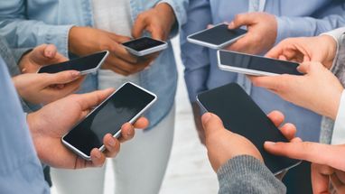 Люди, що стоять у колі зі смартфонами