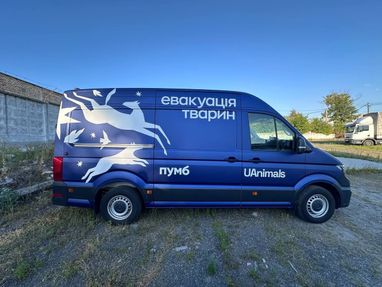 Синій фургон зоозахисного проєкту UAnimals та банку ПУМБ, стоїть під ясним блакитним небом, готовий вирушити на порятунок.