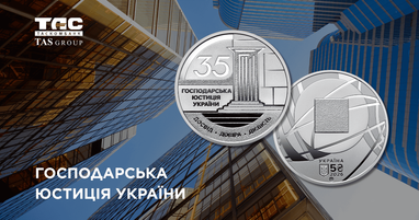 На фоні сучасних скляних хмарочосів та синього неба зображено дві монети